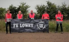 The team pose for a group photo with the FK Lowry banner